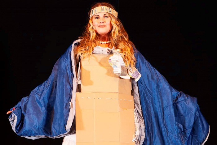 Plus-size model Cat wears cardboard box on catwalk for homeless charity